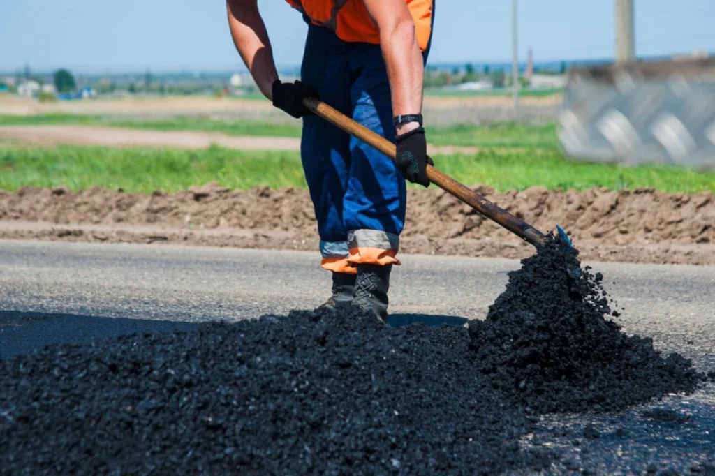 Hawkes Bay Concrete Company worker shoveling asphalt for Asphalt Contractors Hawkes Bay services.